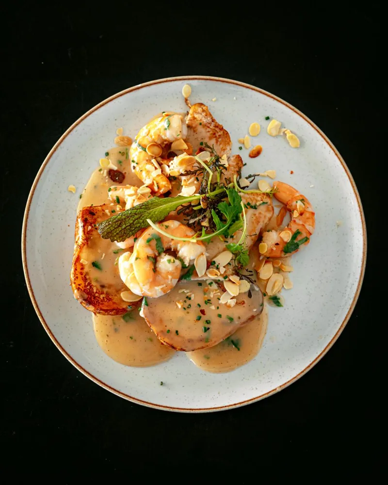 Buziano visto desde arriba: pescado en salsa de camarones con papas gratinadas